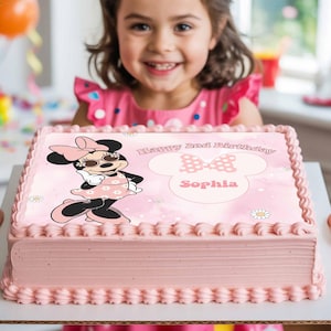 May include: A pink rectangular cake with a Minnie Mouse design. The cake features the text "Happy 2nd Birthday" and the name "Sophia". The cake is decorated with pink frosting and a scalloped edge.