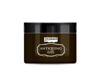 May include: A square jar of antiquing gel with a black lid. The jar is dark brown with a white label that reads "ANTIQUEING GEL" in a decorative font. The brand name "penari" is above the label.