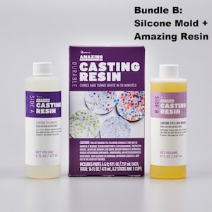May include: A casting resin kit with two bottles labeled "Side A" and "Side B", and a purple box. The box reads "Amazing Casting Resin" and "Cures and turns white in 10 minutes." Each bottle contains 8 fl oz / 237 ml.