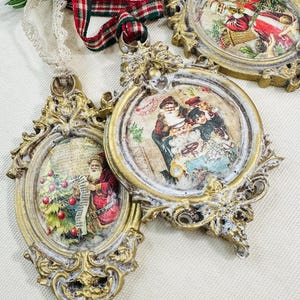 May include: Ornate, gold-colored Christmas ornaments with vintage-style Santa Claus illustrations. Each ornament has a unique shape and is accented with white paint. A red and green plaid ribbon and lace are visible.