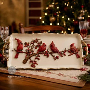 May include: A rectangular cream-colored serving tray with gold-toned handles, featuring a raised relief design of four red cardinal birds perched on a brown branch with red berries. The text #684464 Cardinal Grace is printed on the tray surface.