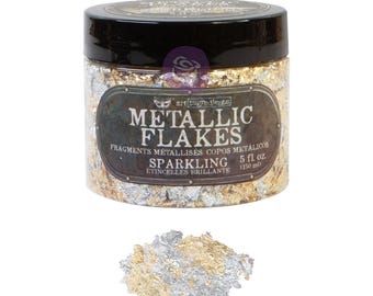 May include: A clear plastic jar filled with gold and silver metallic flakes, topped with a black lid. The label reads "METALLIC FLAKES SPARKLING" and "5 fl. oz. (150 ml)". A small pile of the gold and silver flakes sits in front of the jar.