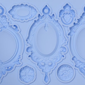 May include: A light blue silicone mold featuring various ornate frame designs. The mold includes oval and round frames with detailed scrollwork and decorative elements, suitable for crafting projects.