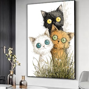 May include: A framed art print featuring three cartoon cats with large, expressive eyes. The cats are a mix of black, white, and orange, peering out from behind tall grass. The artwork has a whimsical, illustrative style, with a white background.