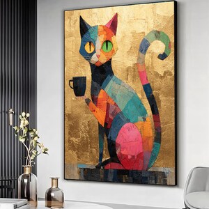 May include: A colorful cat art print. The cat is depicted in a patchwork style, holding a black cup. The background is a textured gold color. The cat's face is split into sections of blue, orange, and pink. The cat has yellow and green eyes.