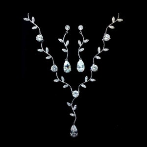 Op de afbeelding: Een zilveren ketting- en oorsteensets met een delicaat rankontwerp en heldere zirkonia-stenen. De ketting heeft een lange hanger met een traanvormige steen.