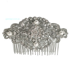 May include: Silver hair comb with a large, ornate design featuring clear rhinestones and faux pearls. The comb has a wide, flat base with a row of teeth.