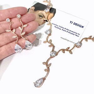Op de afbeelding: Een gouden ketting- en oorsteensets met een delicaat rankontwerp en heldere zirkonia-stenen. De ketting heeft een druppelvormige steen aan het einde. YJ DESIGN Sieraden, Mode & Haaraccessoires voor Bruiloften, Evenementen & Dagelijkse Kleding www.yjdesign.com.au