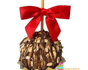 May include: A chocolate caramel apple topped with chopped almonds and drizzled with chocolate. The apple is on a gold paper wrapper and has a red bow on top.