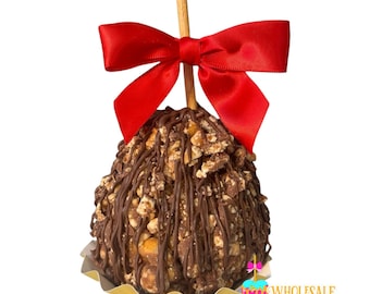 May include: A chocolate-covered caramel apple topped with chopped peanuts and drizzled with chocolate. The apple is on a gold paper wrapper and has a red bow on top.