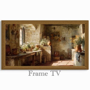 Puede incluir: Impresión enmarcada de una escena de cocina rústica. La obra de arte representa una habitación con paredes de piedra con una mesa de madera, ollas y flores. La paleta de colores es cálida, con marrones, beiges y toques de verde. El texto "Frame TV" está en la parte inferior.