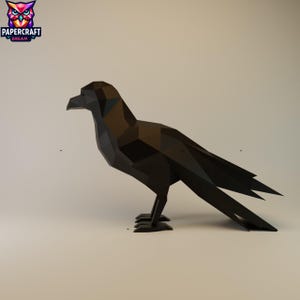 May include: A black, geometric papercraft raven sculpture. The raven is standing with its wings slightly spread, showcasing a detailed, angular design. The Papercraft Dream logo is in the upper left corner.