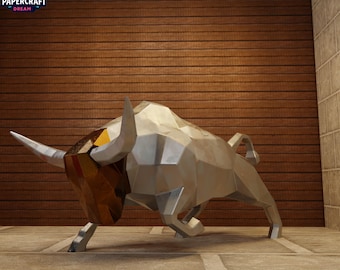 May include: A silver geometric sculpture of a bull with a brown and gold head. The sculpture is standing on a concrete surface in front of a wooden wall. The Papercraft Dream logo is in the upper left corner.