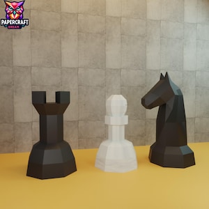 Puede incluir: Tres piezas de ajedrez geométricas: una torre negra, un peón blanco y un caballo negro. Las piezas están sobre una superficie amarilla y una pared texturizada de color marrón claro. El logotipo "PAPERCRAFT DREAM" está en la esquina superior izquierda.