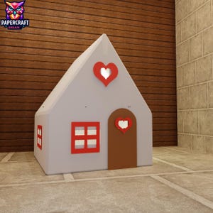 May include: A gray, house-shaped playhouse with a red heart cutout on the roof and door. The house has a red window and a red frame around the door. The logo "PAPERCRAFT DREAM" is in the upper left corner.