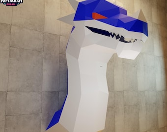 May include: A large, geometric papercraft dragon head mounted on a wall. The dragon has a white body, blue head and accents, and an orange eye. The Papercraft Dream logo is in the upper left corner.
