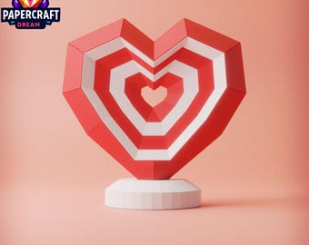 May include: A red and white papercraft heart with a geometric design. The heart is on a white base and has a small heart-shaped hole in the center.