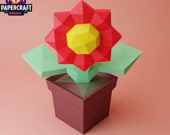 May include: A red paper flower with a yellow center in a brown pot. The flower and pot are made of paper and have a geometric design.