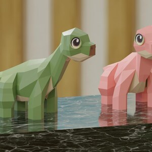 May include: Two papercraft dinosaurs, one green and one pink, standing on a black marble surface. The dinosaurs have large eyes and are made of folded paper.