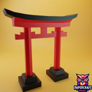 May include: A red and black Torii gate model, a traditional Japanese structure, stands on a black base against a yellow background. The model features a curved top and is made of geometric shapes. The Papercraft Dream logo is in the bottom right corner.