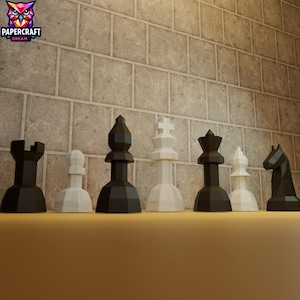May include: A set of black and white chess pieces arranged on a flat surface. The pieces include a rook, pawn, bishop, king, queen, and knight. The background features a brick wall and the Papercraft Dream logo.