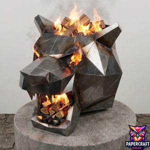 Könnte beinhalten: Eine geometrische Feuerstelle aus Metall in Form eines Pantherkopfes mit dunkler, verwitterter Oberfläche. Die Struktur weist scharfe, kantige Facetten und ein offenes Maul mit brennenden Holzscheiten auf, wobei Flammen durch Augen und Maul dringen.
