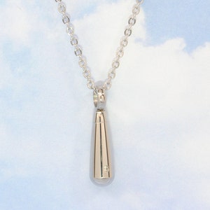 May include: A silver teardrop-shaped pendant necklace. The pendant is on a silver chain.