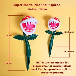 May include: Super Mario Piranha Plant-inspired stakes decor. Each stake features a red and white head with a pink mouth and white teeth. The stakes are green, with a total height of 17.78 cm and 13.97 cm. The text says, "Super Mario Piranha inspired stakes decor."