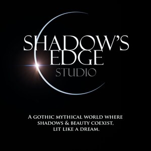 以下が含まれることがあります： 黒い背景に、白い文字で「SHADOW'S EDGE STUDIO」と三日月型のデザイン。下には「A GOTHIC MYTHICAL WORLD WHERE SHADOWS & BEAUTY COEXIST, LIT LIKE A DREAM.」と書かれています。