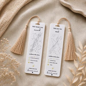 May include: Two white rectangular bookmarks with beige tassels. The left bookmark reads THE NIGHT YOU arrived, written in the stars, MURDOCH HOSPITAL, 17TH JUNE 2016, 9.55PM, FOREVER OUR favourite moment. The right reads THE DAY WE met, written in the stars, COMO PUB, 15TH APRIL 2026, 7PM, FOREVER OUR favourite moment.