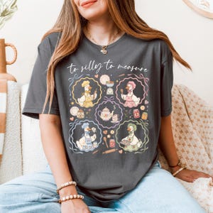 May include: Dark gray t-shirt with the text "to silly to measure" and illustrations of geese in chef hats and aprons. The geese are depicted in various kitchen scenes, surrounded by decorative frames with pastel colors.