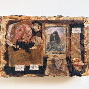 May include: Mixed media artwork with a collage aesthetic. The piece features a central image of two dark figures, possibly birds, with a pink and brown floral element. The artwork incorporates various textures and colors, including black, brown, and red.