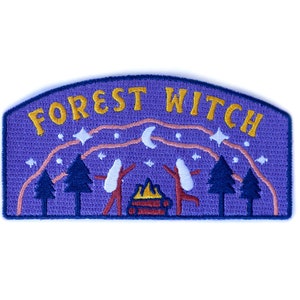 K&ouml;nnte beinhalten: Gestickter Aufn&auml;her mit lila Hintergrund und den Worten "FOREST WITCH" in Gold. Das Design umfasst ein Lagerfeuer, B&auml;ume, Sterne und zwei Figuren mit erhobenen Armen. Der Aufn&auml;her hat einen blauen Rand.