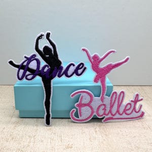 May include: Three embroidered patches with ballet themes. One patch features a black ballerina with the word "Dance" in purple script. Another shows a pink ballerina with the word "Ballet" in pink script.