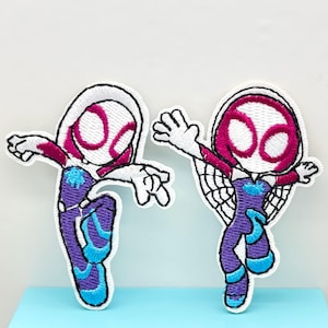 May include: Two embroidered iron-on patches featuring a cartoon character in a white and purple suit with a pink spider symbol on the chest. The character is in a jumping pose with one leg raised.