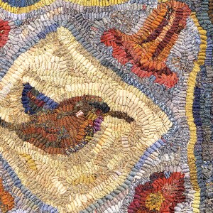 May include: Close-up of a handmade rug with a bird design. The rug features a central diamond shape with a bird motif in shades of brown, blue, and purple. The background has a mix of beige, gray, and red colors.