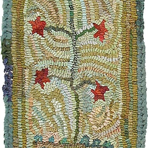May include: A hand-woven rug featuring a floral design. The rug is made from colourful fabric scraps and depicts a green plant with red flowers in a brown pot. The rug has a green, brown and gold border.