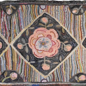 Puede incluir: Una alfombra vintage hecha a mano con un patrón geométrico de diamantes y flores. La alfombra está hecha con una variedad de colores, incluyendo rosa, azul, verde y marrón.