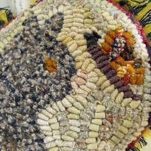 May include: Close-up of a colorful, hand-woven rug with a variety of textures and patterns. The rug is made of different colored yarns and has a fringed edge.