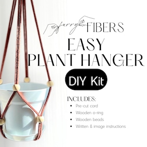 May include: A DIY plant hanger kit with the text "EASY PLANT HANGER DIY Kit." The kit includes pre-cut cord, wooden o-ring, wooden beads, and instructions. The plant hanger is made of brown cord and wooden beads, holding a white pot.
