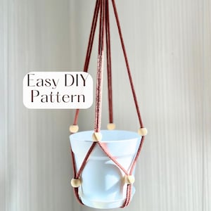 Peut inclure: Un porte-plante suspendu avec un pot blanc suspendu par une corde marron et des perles en bois. Le texte "Easy DIY Pattern" est affiché sur le côté gauche de l'image. Le porte-plante est conçu pour être suspendu au plafond ou à un crochet.