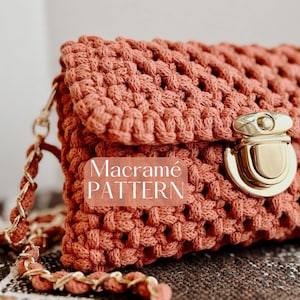 May include: A coral-colored macramé handbag with a gold-tone clasp and chain strap. The bag features a woven texture and the words "Macramé PATTERN" are printed on the front. The bag is a stylish accessory.
