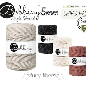 May include: Four spools of 5mm single strand cotton cord in natural, black, white, and terracotta colors. The cord is labeled "Bobbiny" and is advertised as "Ships Fast".
