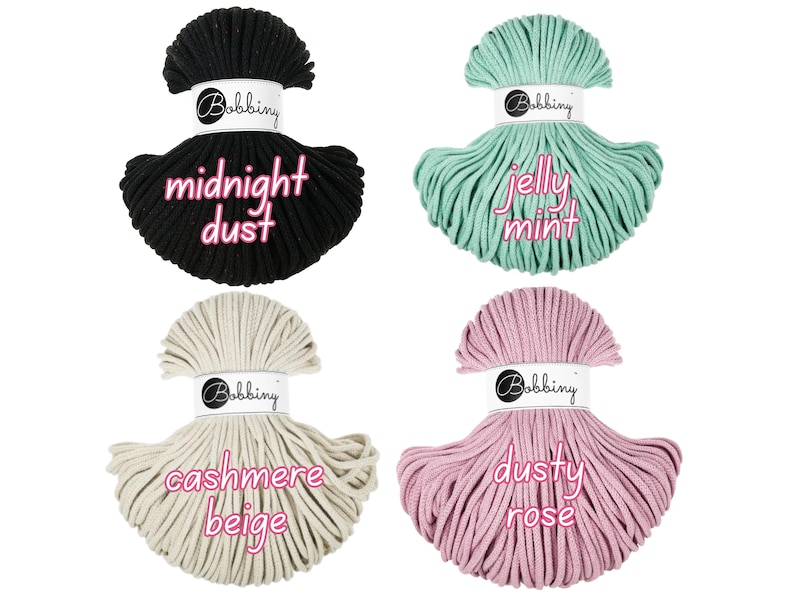 May include: Four spools of macrame cord in various colors: black with "midnight dust" text, mint green with "jelly mint" text, beige with "cashmere beige" text, and pink with "dusty rose" text. Each spool has a white label with the "Bobbing" logo.