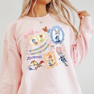 A woman wearing a pink sweatshirt with various cartoon animal characters and a pink bow on it.