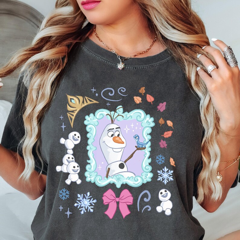 A woman wearing a black t-shirt with a graphic design featuring characters from the Disney movie Frozen.