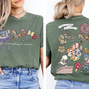 a woman wearing a green t-shirt with a cartoon character design on the front and the back.