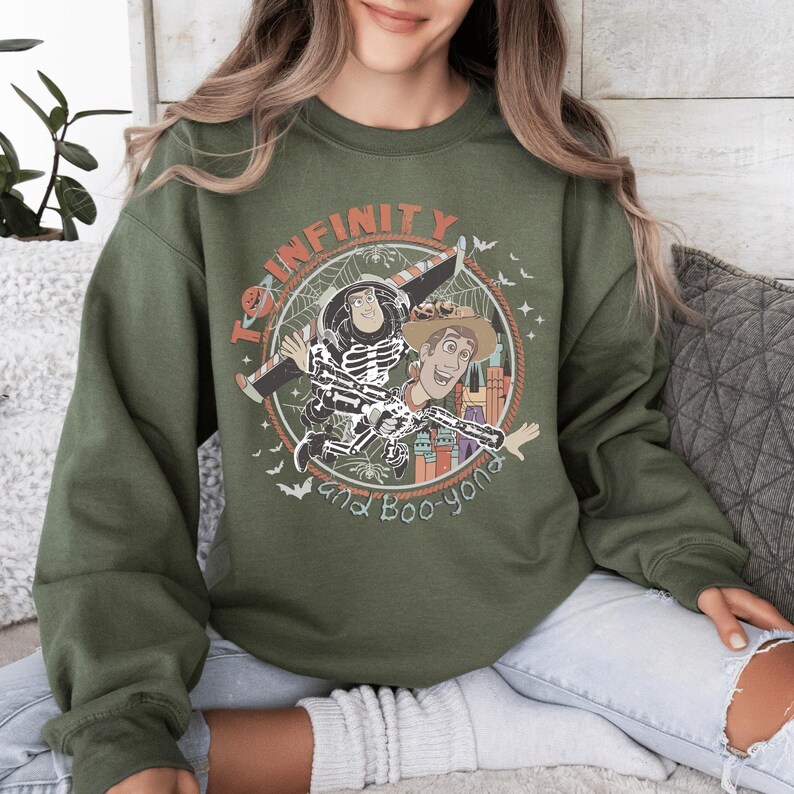 A woman wearing a green sweatshirt with a graphic design featuring characters from the Toy Story franchise.