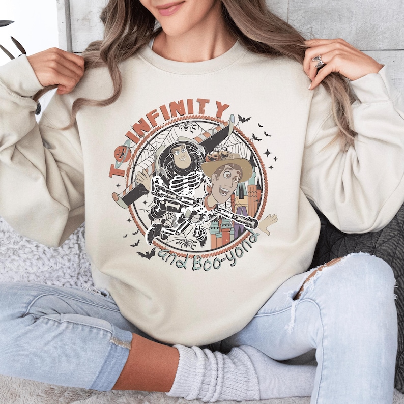 A woman wearing a white sweatshirt with a graphic design featuring characters from the Toy Story franchise.