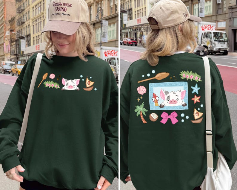 A woman wearing a green sweater with a pig design and various other decorative elements on the back.